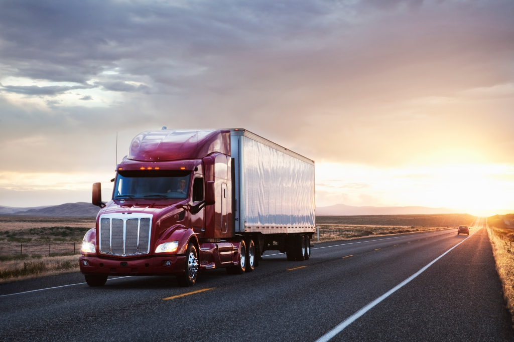 SACC Career Center CDL graduate driving semi truck on open highway at sunset