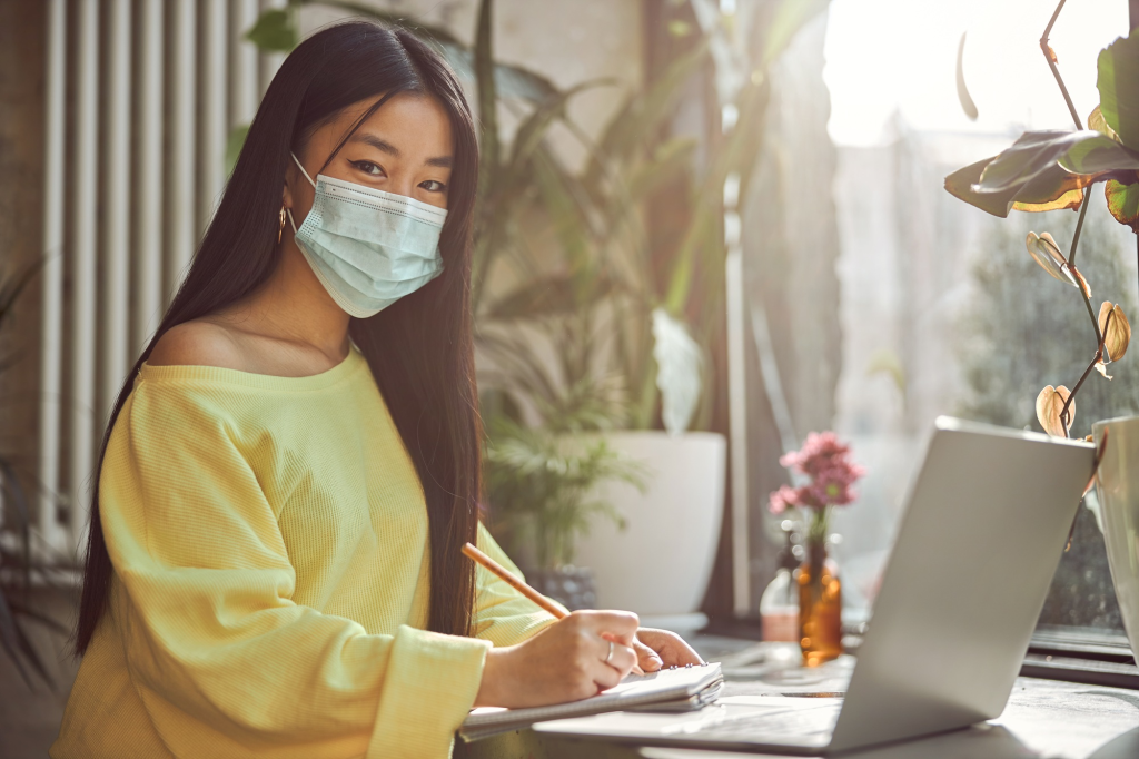 SACC Career Center student studying online coursework while wearing a face mask