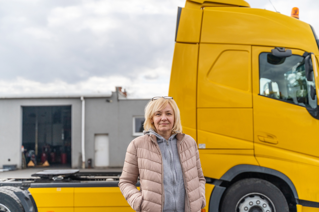SACC Career Center CDL training student standing proudly beside yellow semi truck during hands on driving practice