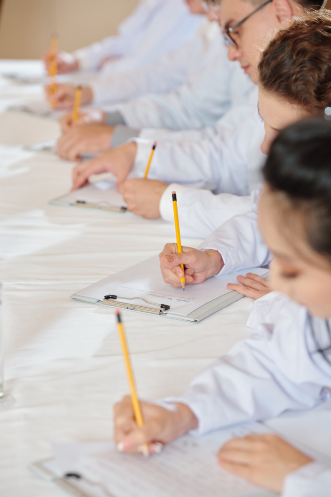 SACC Career Center students in lab coats taking notes during classroom training session